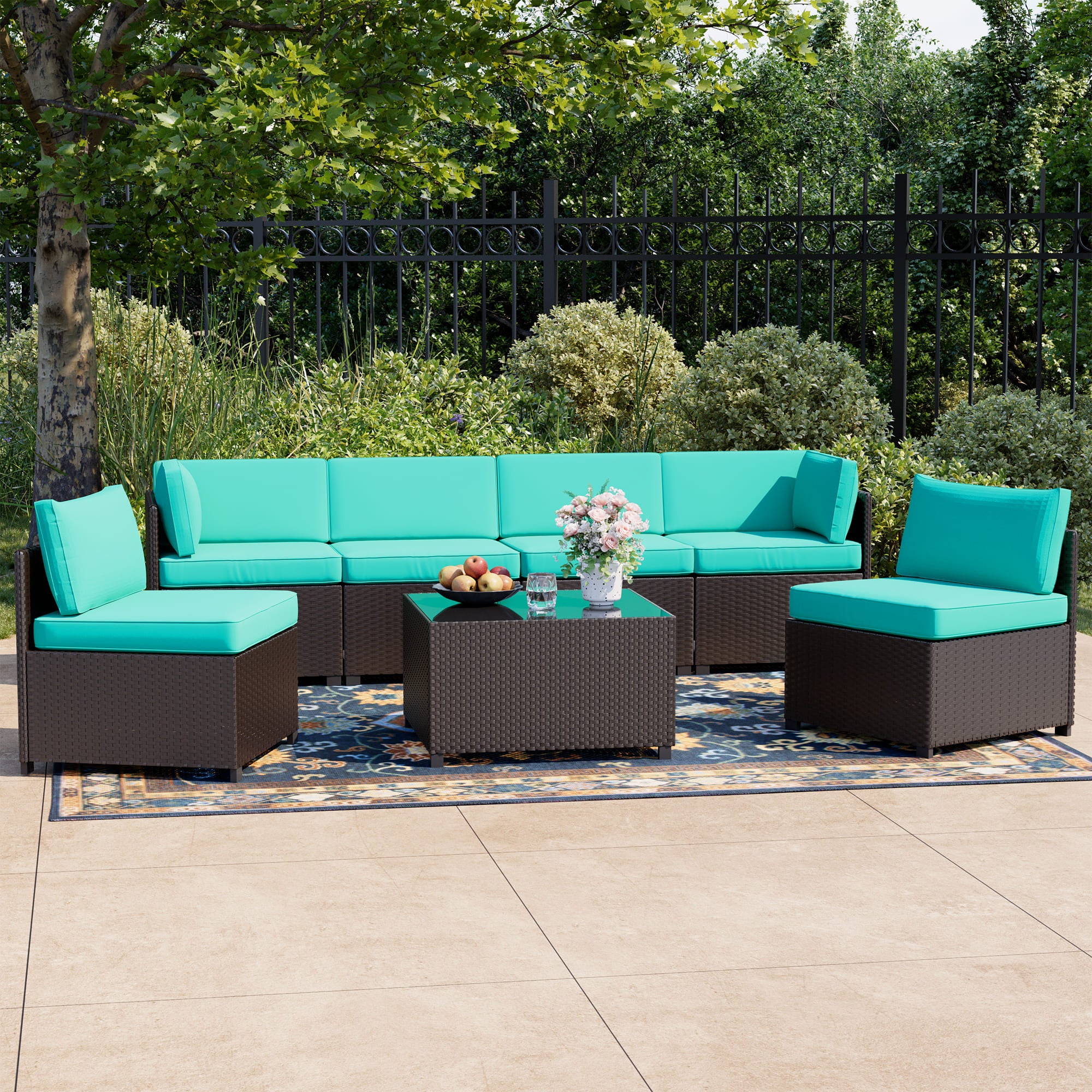 7-piece rattan patio sectional sofa set with cushions and glass-top table on outdoor deck