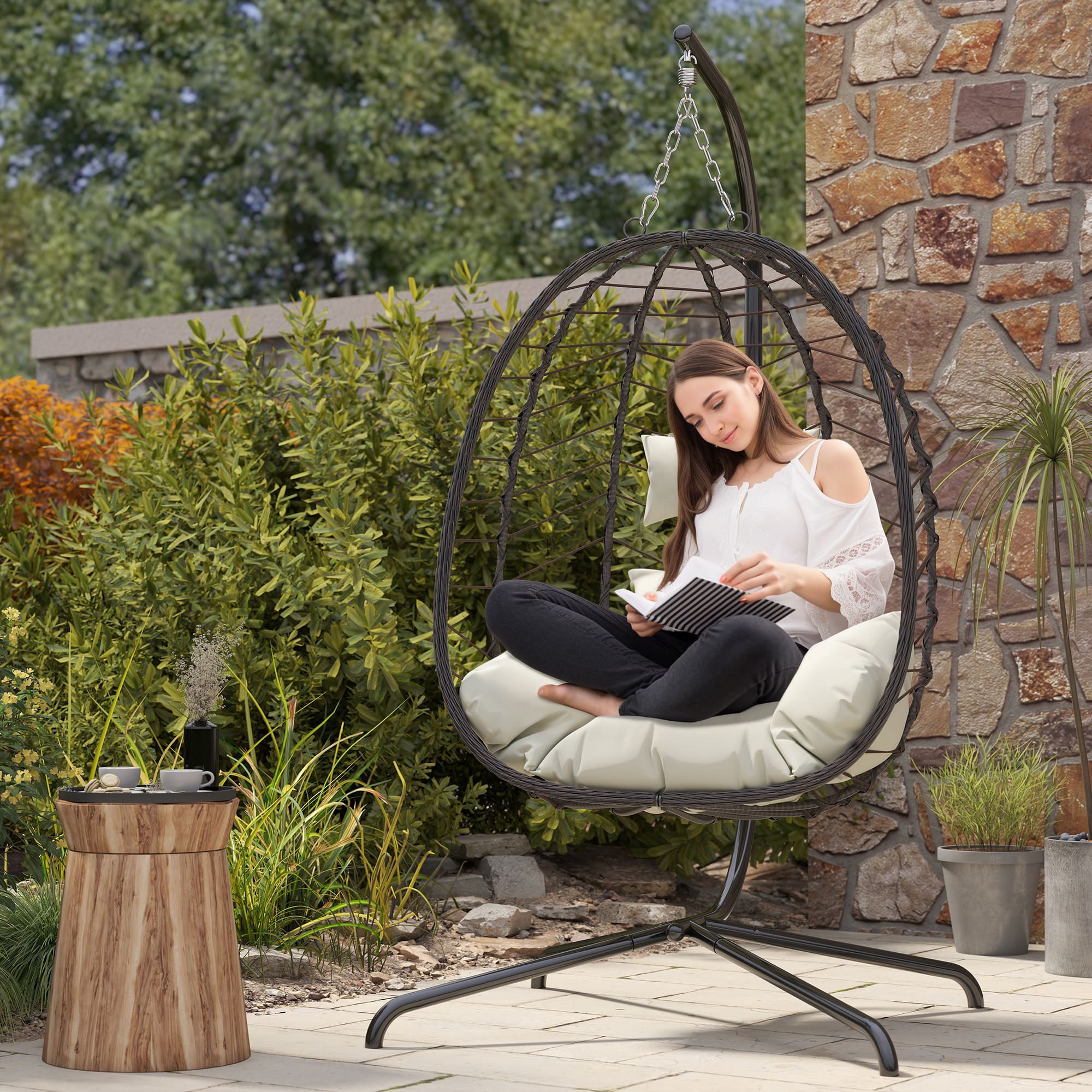 Woman lounging in beige hanging egg chair on balcony with soft cushions